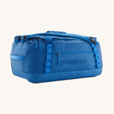 Patagonia black hole duffel bag in endless blue colour on a cream background