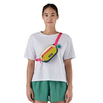 A woman wearing the Terravia mini bum bag from Patagonia, strapped over one shoulder so that is crosses over her chest. 