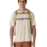 Patagonia lid fieldsmith lid backpack in classic tan worn by an adult on the back. Showing the shoulder straps detail with buckle fastening. 