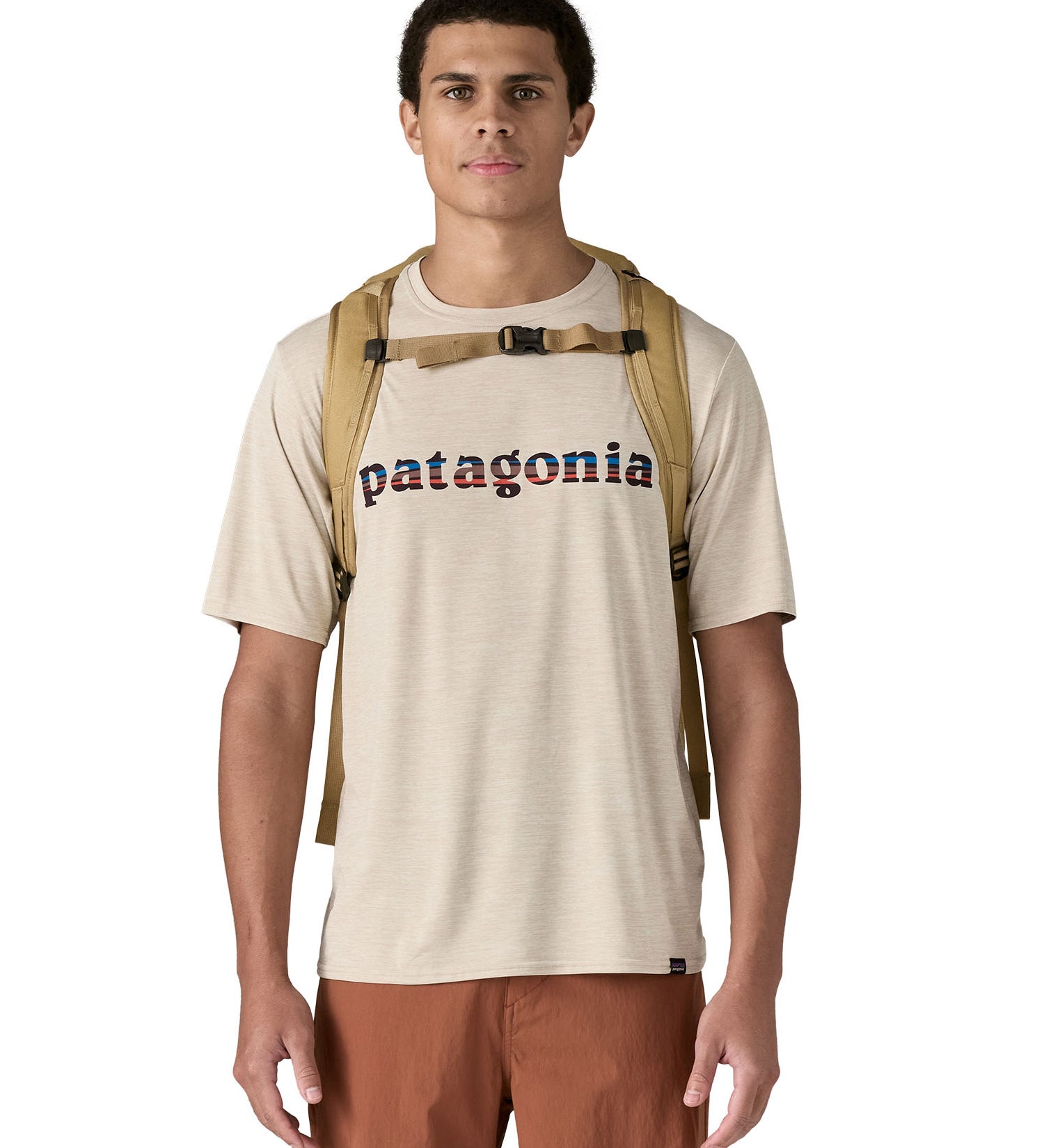 Patagonia lid fieldsmith lid backpack in classic tan worn by an adult on the back. Showing the shoulder straps detail with buckle fastening. 
