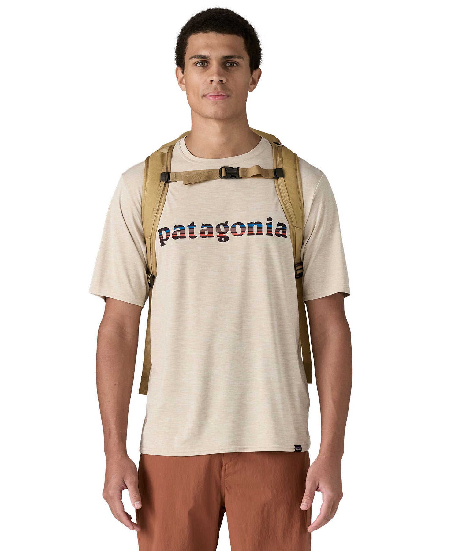 Patagonia lid fieldsmith lid backpack in classic tan worn by an adult on the back. Showing the shoulder straps detail with buckle fastening. 