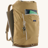Patagonia fieldsmith roll top backpack in classic tan with zipped compartments and laptop sleeve at the back.