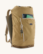 Patagonia fieldsmith roll top backpack in classic tan with zipped compartments and laptop sleeve at the back.