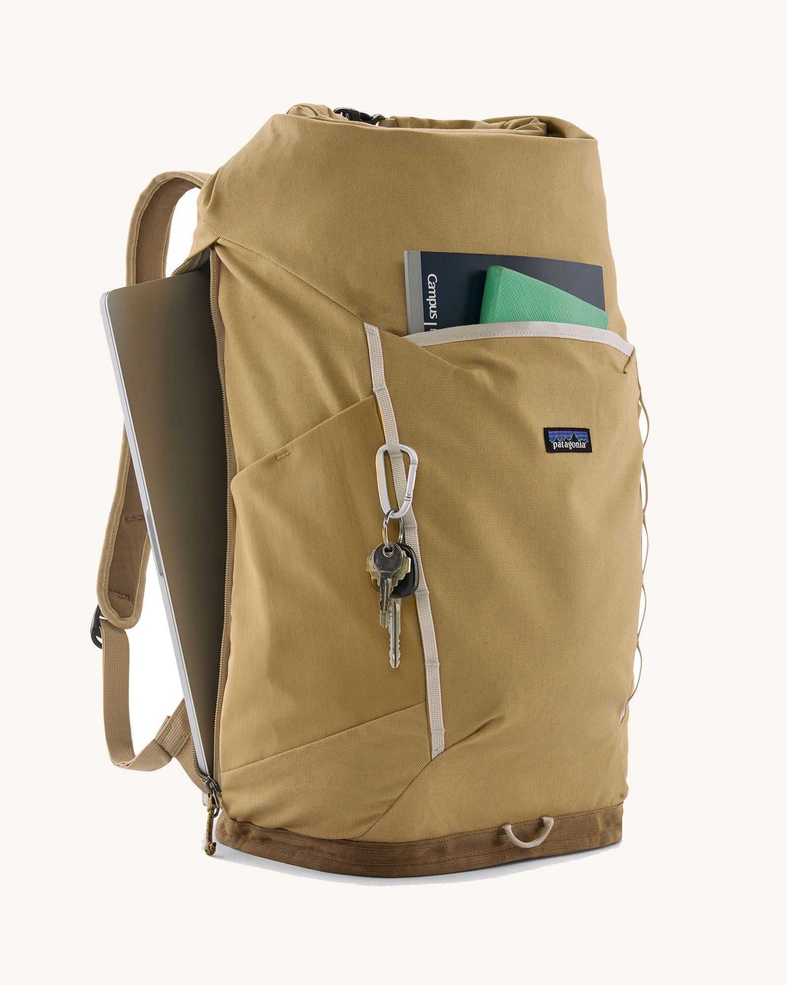 Patagonia fieldsmith roll top backpack in classic tan with zipped compartments and laptop sleeve at the back.