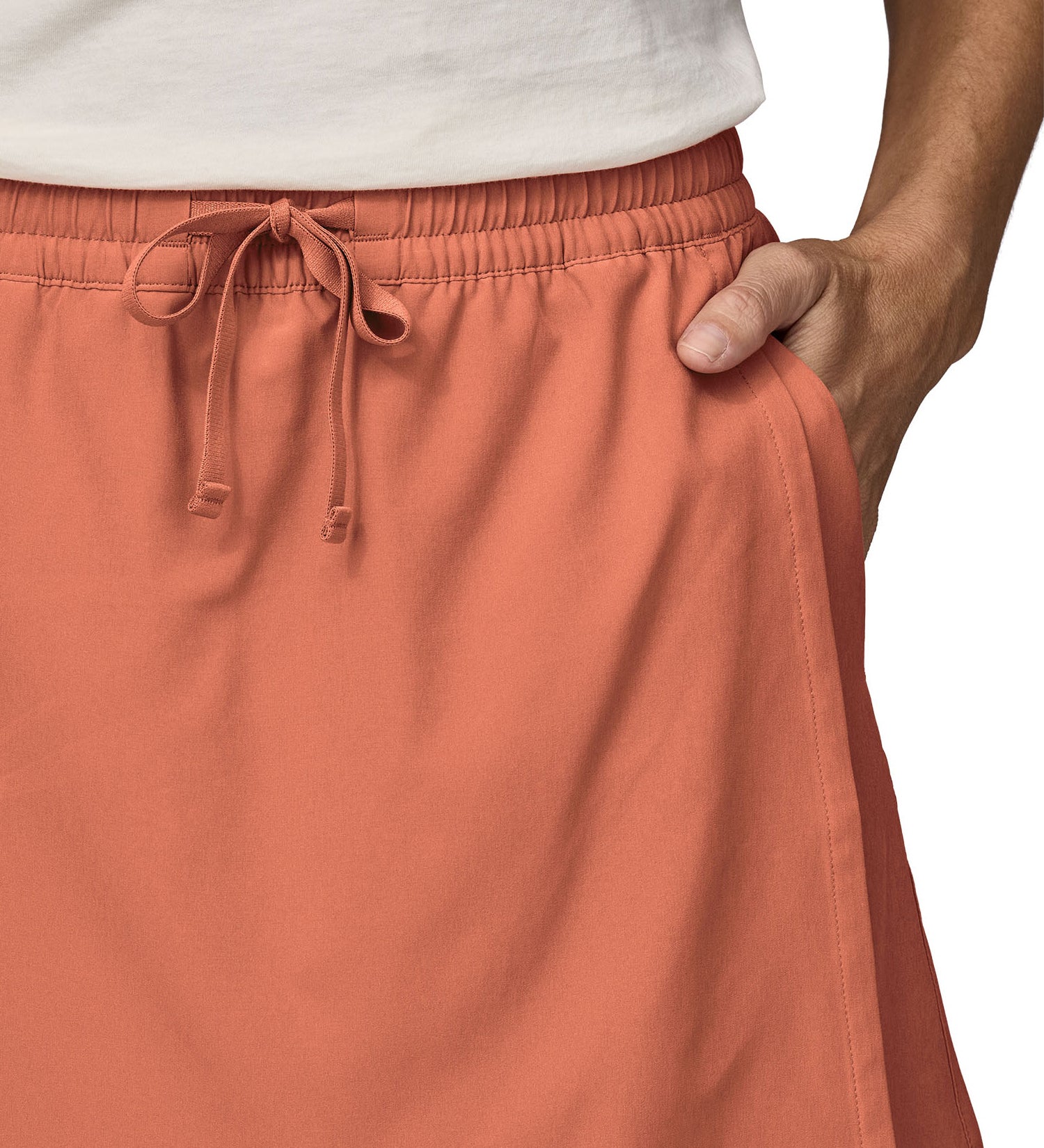 Patagonia women's fleetwith skort in a pastel orange colour worn by a woman front pocket detail