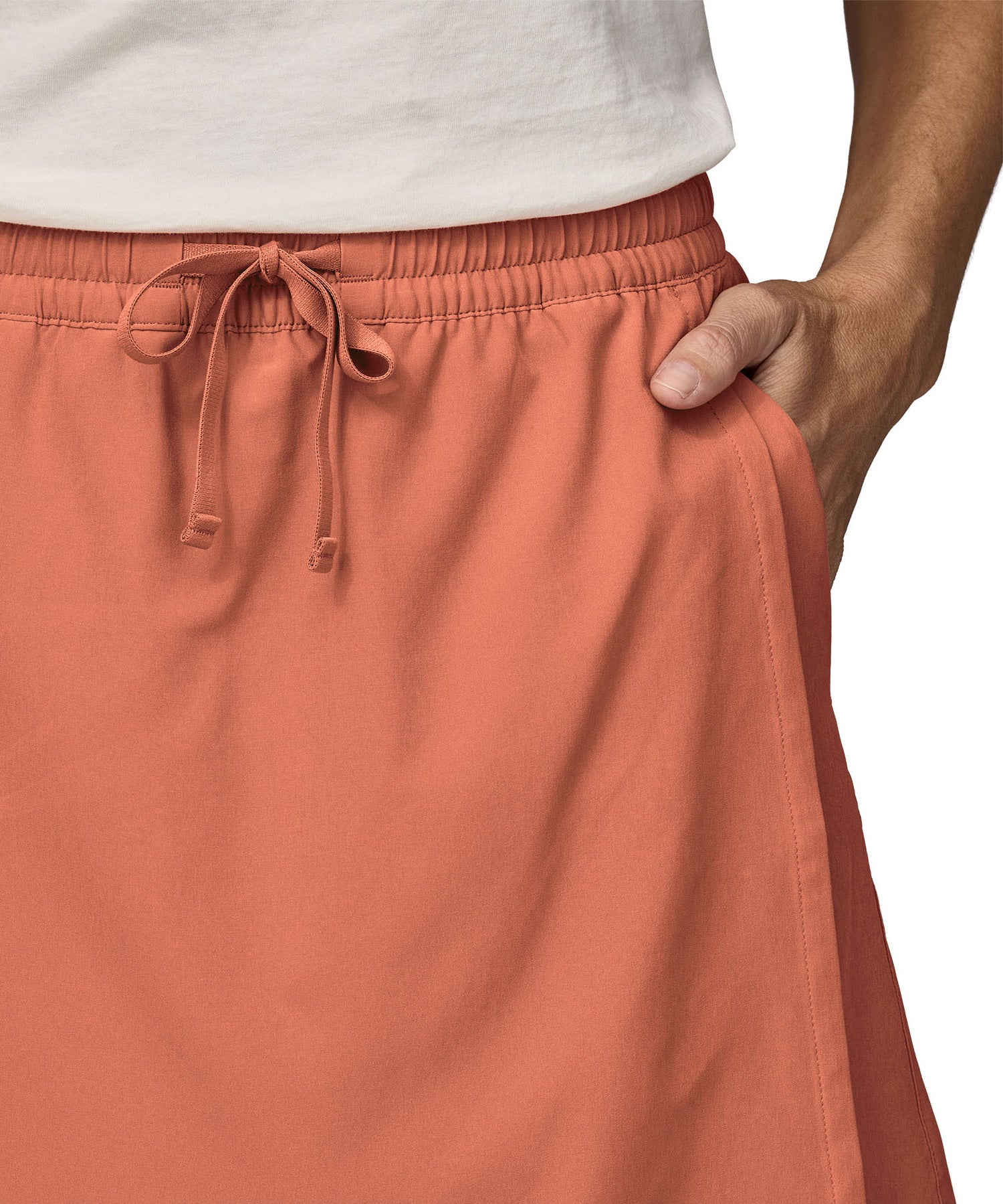 Patagonia women's fleetwith skort in a pastel orange colour worn by a woman front pocket detail