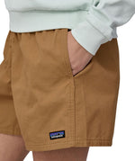 Patagonia women's funhogger shorts in brown worn by a woman front pocket detail