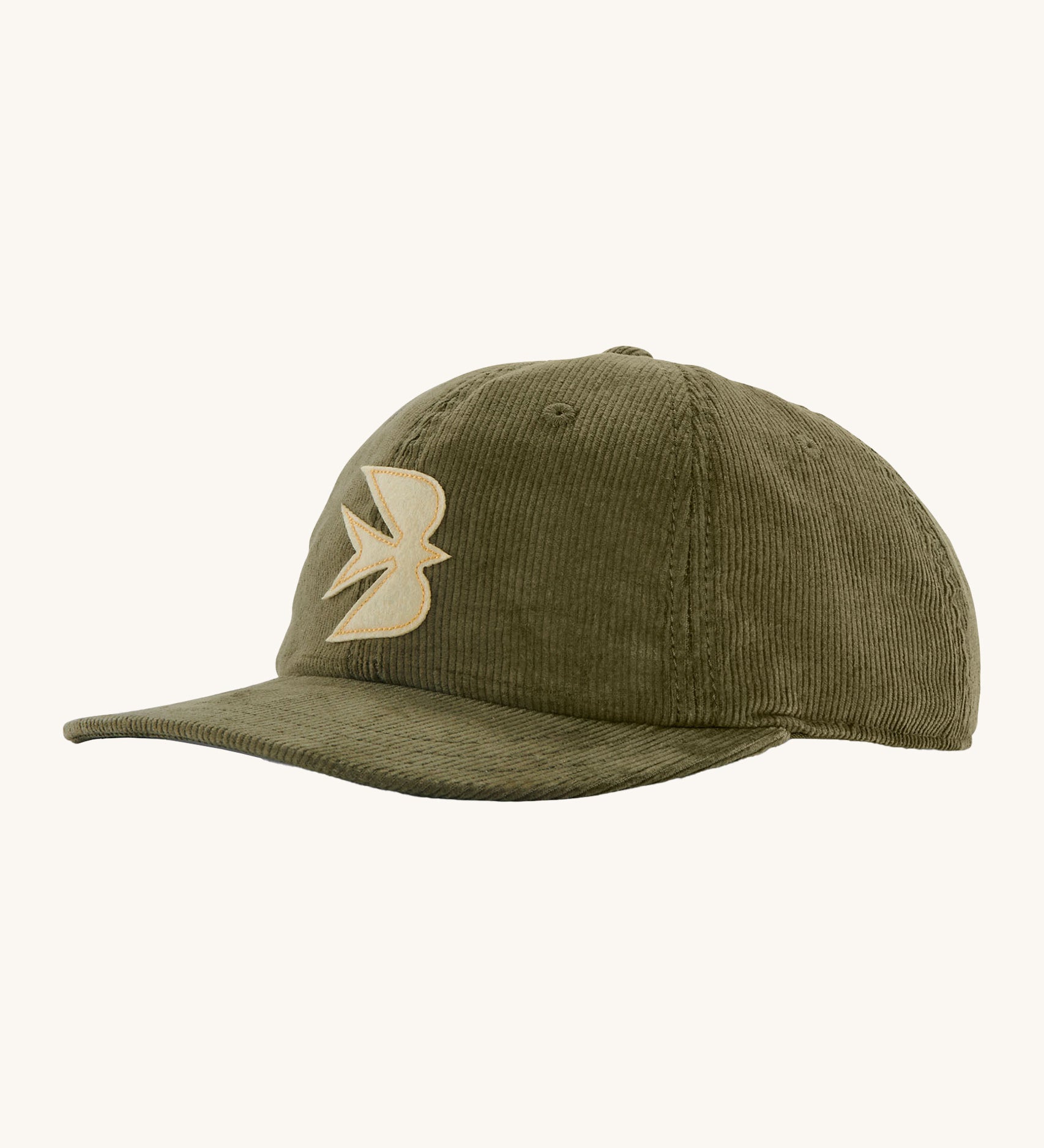 Patagonia green corduroy cap with a light yellow swallow design on the front on a cream background.
