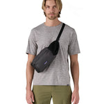 Patagonia terravia hip bag in a black colour worn by an adult on the shoulder