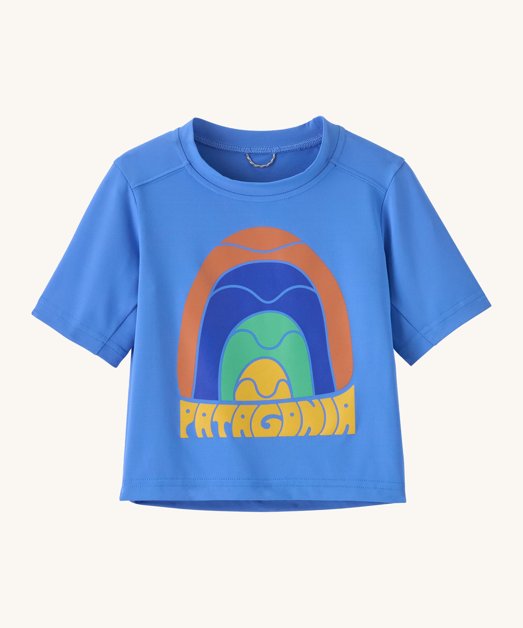 Patagonia kids blue short sleeve t-short rainbow design on a cream background.