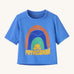 Patagonia kids blue short sleeve t-short rainbow design on a cream background.