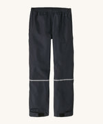 Patagonia kids torrentshell rain trousers on a cream background.