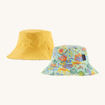 Patagonia kids bucket hat in a pastel yellow colour, green colour and multicoloured pattern design on a cream background.