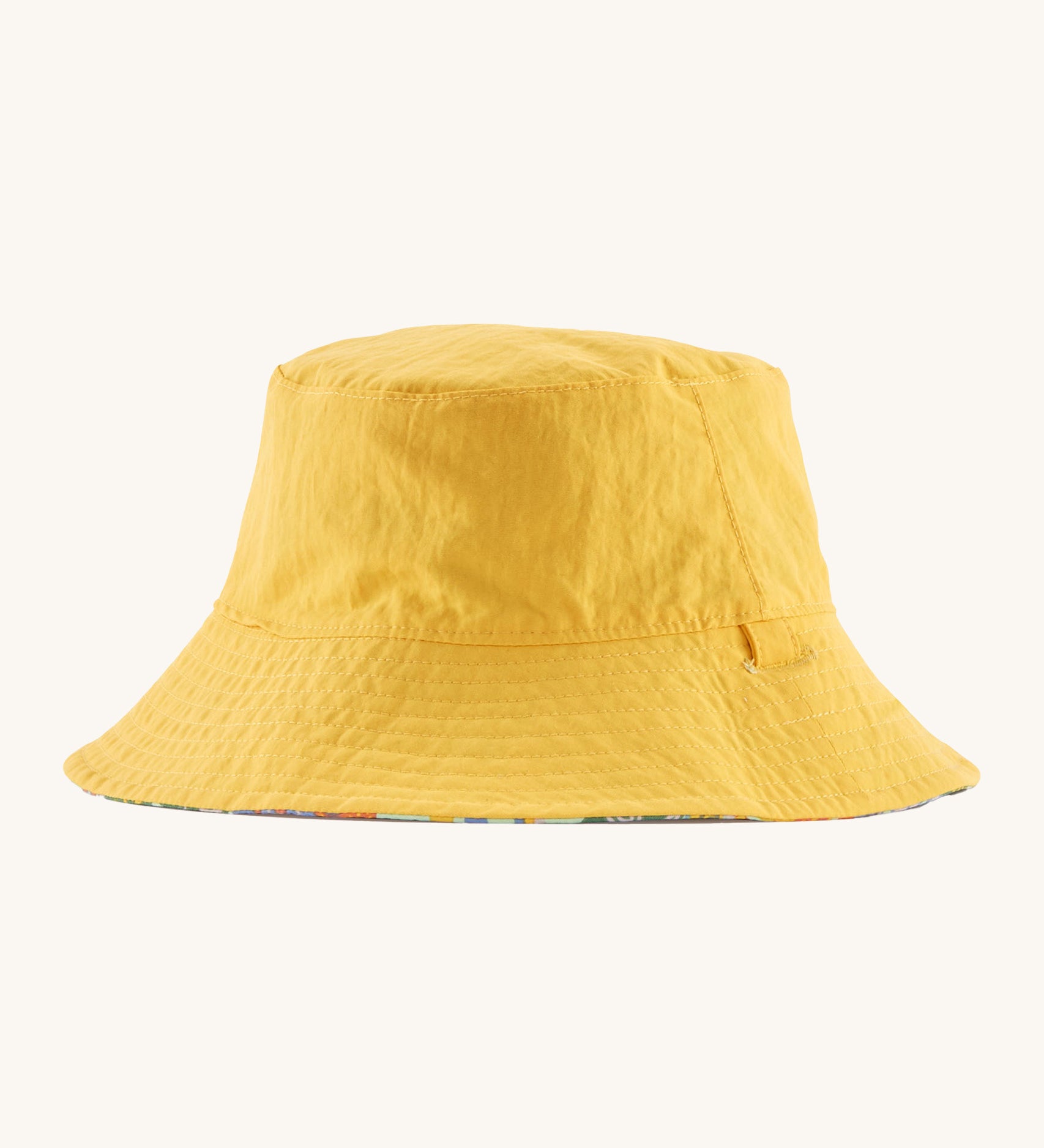 Patagonia kids bucket hat in a pastel yellow colour on a cream background.