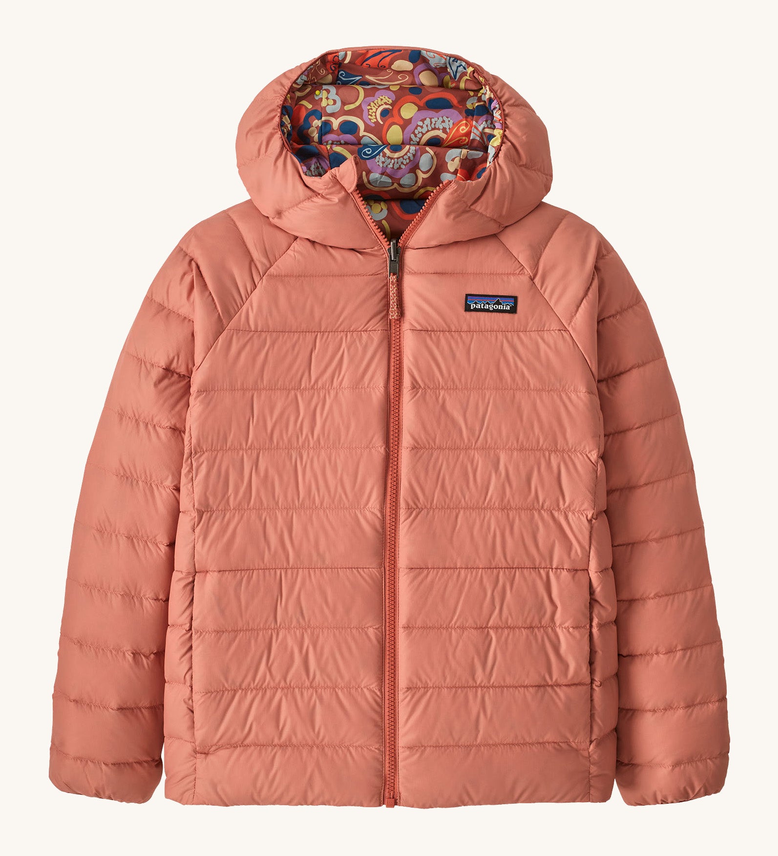 Patagonia Kids Reversible Down Hoody in river river and potters red design. A long sleeve jacket in pale pink featuring a full length zip and a colourful paisley design on the inside