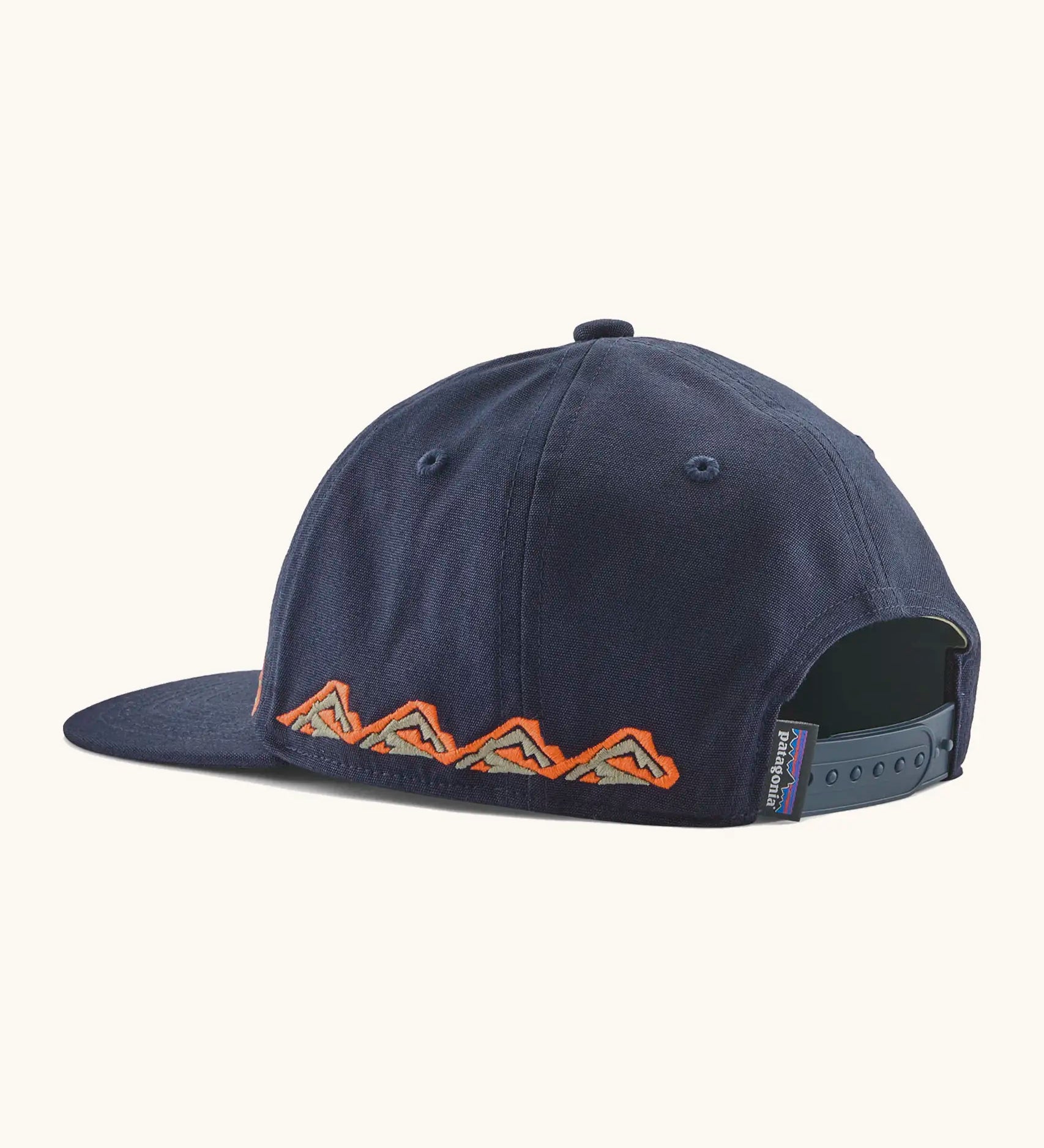 Back of Patagonia kid's funhoggers hat in navy with orange trailtreck pattern around the edge showing size adjustment strap