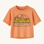 Patagonia kids light orange short sleeve t-short mountain design on a cream background.