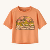 Patagonia kids light orange short sleeve t-short mountain design on a cream background.