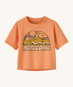Patagonia kids light orange short sleeve t-short mountain design on a cream background.