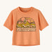Patagonia kids light orange short sleeve t-short mountain design on a cream background.