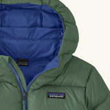 Close up of blue lined hood on the Patagonia kids hi-loft down sweater hoody windproof jacket in canopy green.