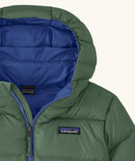 Close up of blue lined hood on the Patagonia kids hi-loft down sweater hoody windproof jacket in canopy green.