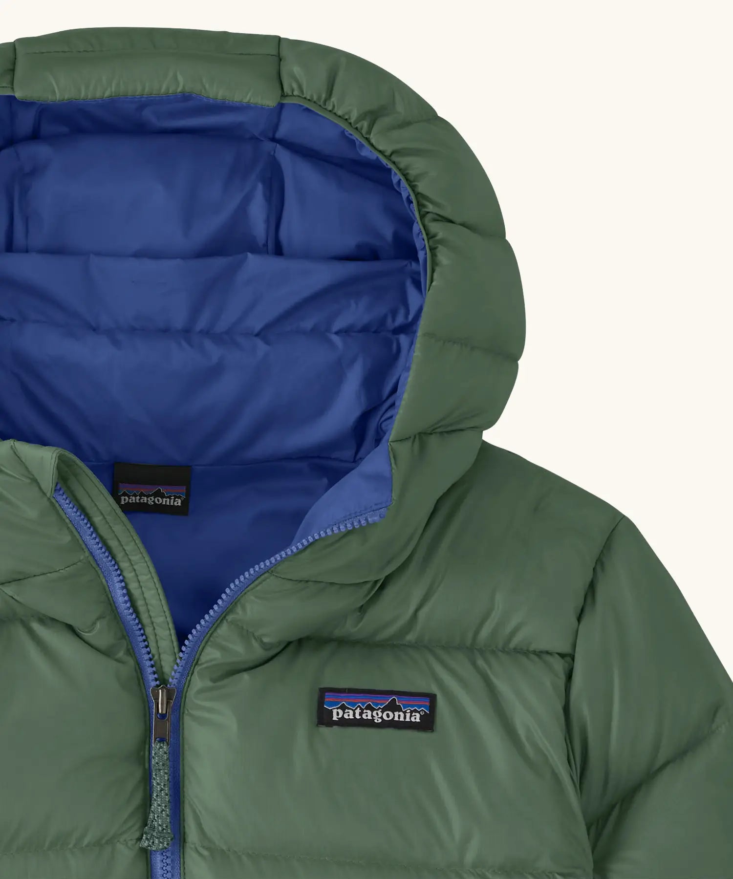 Close up of blue lined hood on the Patagonia kids hi-loft down sweater hoody windproof jacket in canopy green.