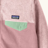 Close up of chest pocket on Patagonia kid's micro-d snap-t hooded jacket in purple and pink showing light green flap