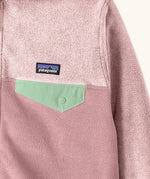 Close up of chest pocket on Patagonia kid's micro-d snap-t hooded jacket in purple and pink showing light green flap