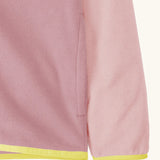 Close up of side pocket on Patagonia kid's micro-d snap-t hooded jacket in purple and pink showing light yellow trim on hem and cuff