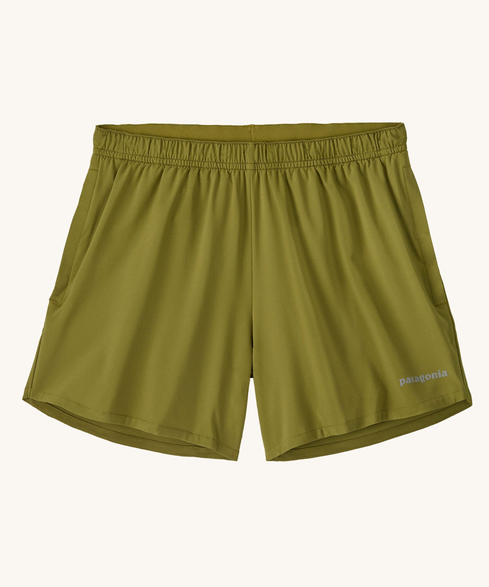 The Patagonia Kids Multi Trails Shorts 4 Inch in Graze Green, technical sports shorts in khaki green with side seam pockets and a minimal elasticated waistband. Made from 90% OceanCycle recycled polyester.