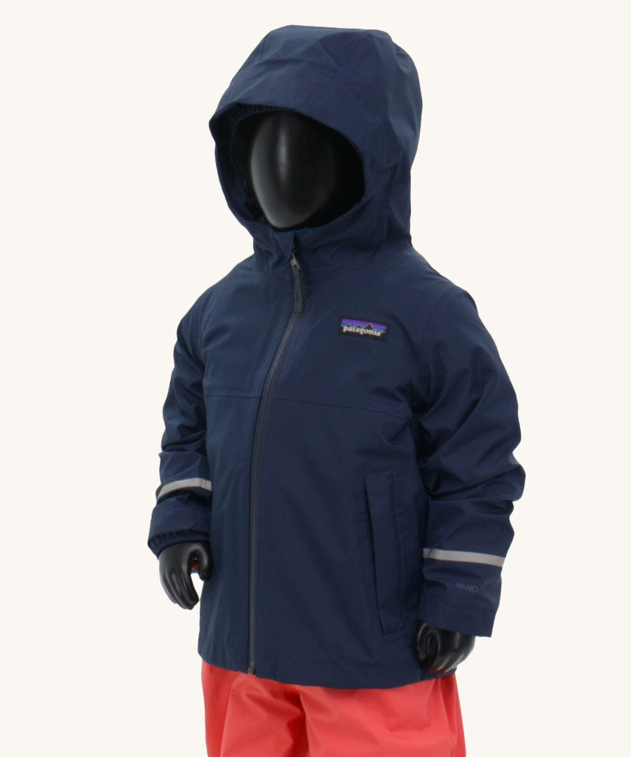 A child's size mannequin wearing the Patagonia Little Kids Torrentshell 3L Waterproof Jacket in a New Navy colour against a plain background.