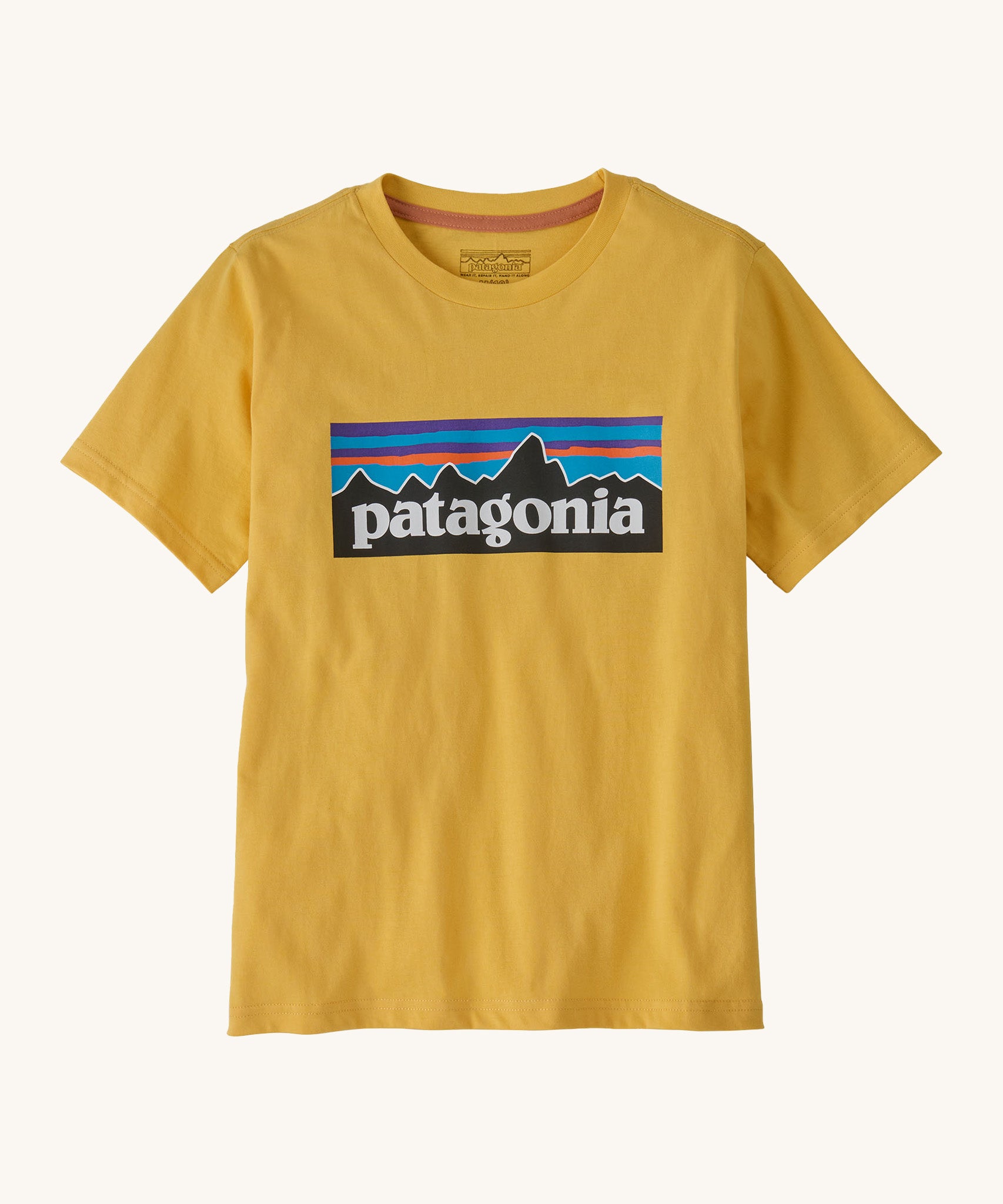 Patagonia kids short sleeve t-shirt in a dark yellow colour on a cream background