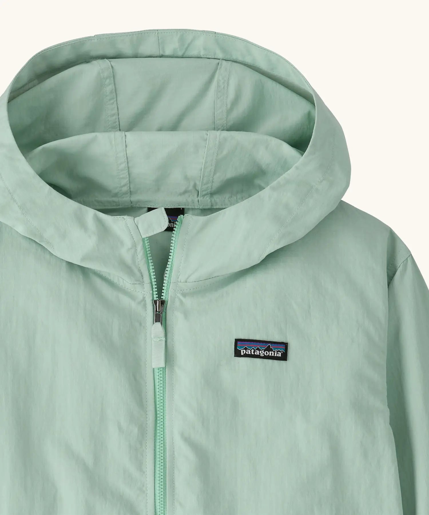 Hood of Patagonia kid's outdoor everyday hooded jacket in light green also showing front zip and small brand chest patch
