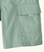 Close up of Patagonia kid's outdoor everyday 6 inch shorts in  light green showing side velcro pocket
