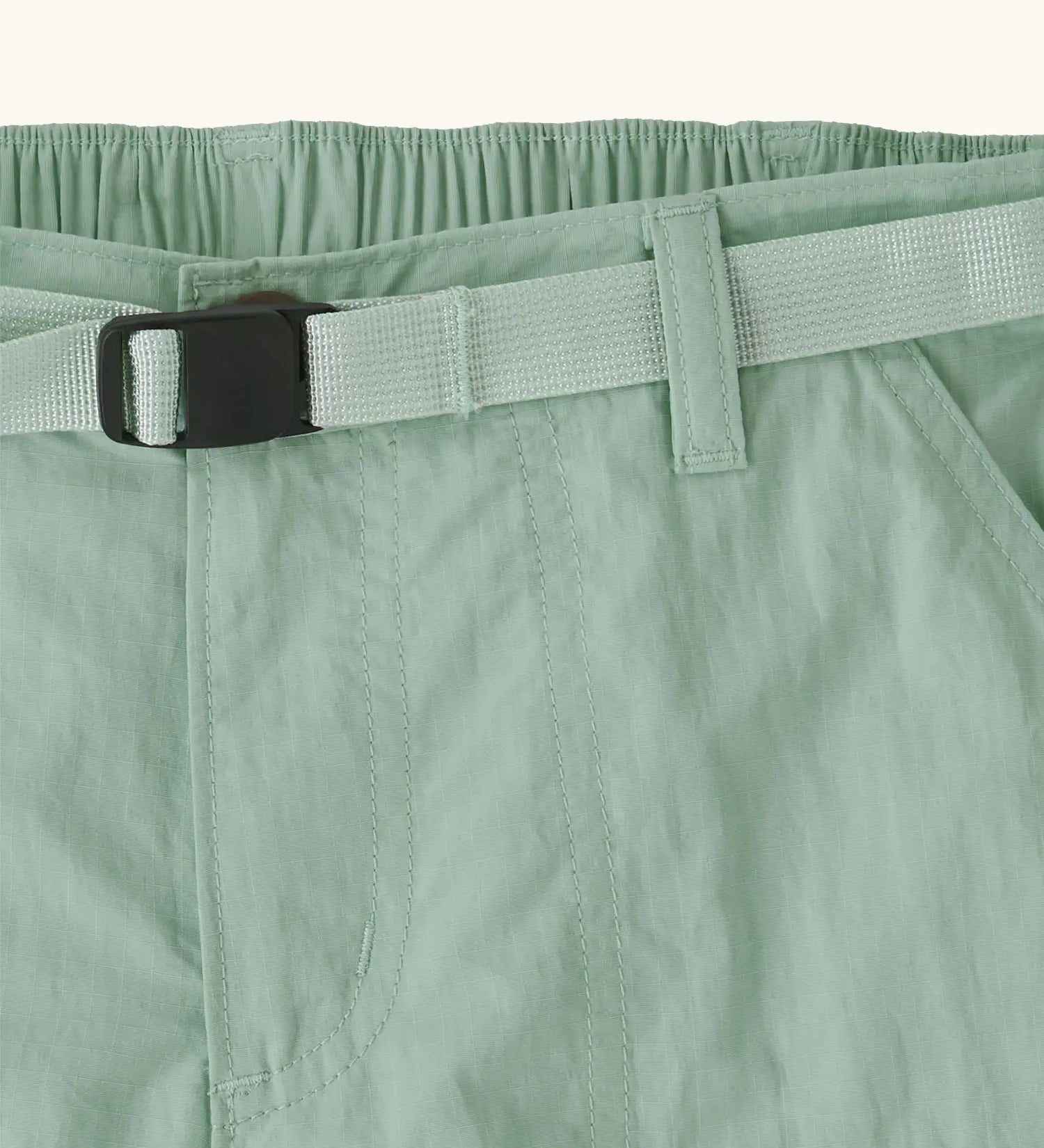 Close up of Patagonia kid's outdoor everyday 6 inch shorts in  light green showing quick release buckle belt.