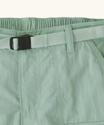 Close up of Patagonia kid's outdoor everyday 6 inch shorts in  light green showing quick release buckle belt.