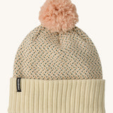 Patagonia kids powder town beanie in confetti/natural. A thick beanie with blue and yellow speckled on natural coloured organic fabric. Features a light pink pom pom on top.