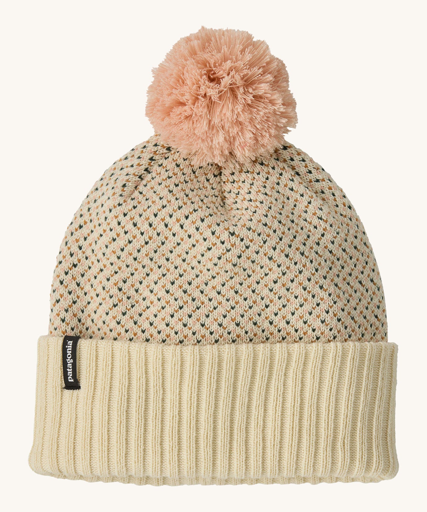 Patagonia kids powder town beanie in confetti/natural. A thick beanie with blue and yellow speckled on natural coloured organic fabric. Features a light pink pom pom on top.