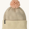 Patagonia kids powder town beanie in confetti/natural. A thick beanie with blue and yellow speckled on natural coloured organic fabric. Features a light pink pom pom on top.