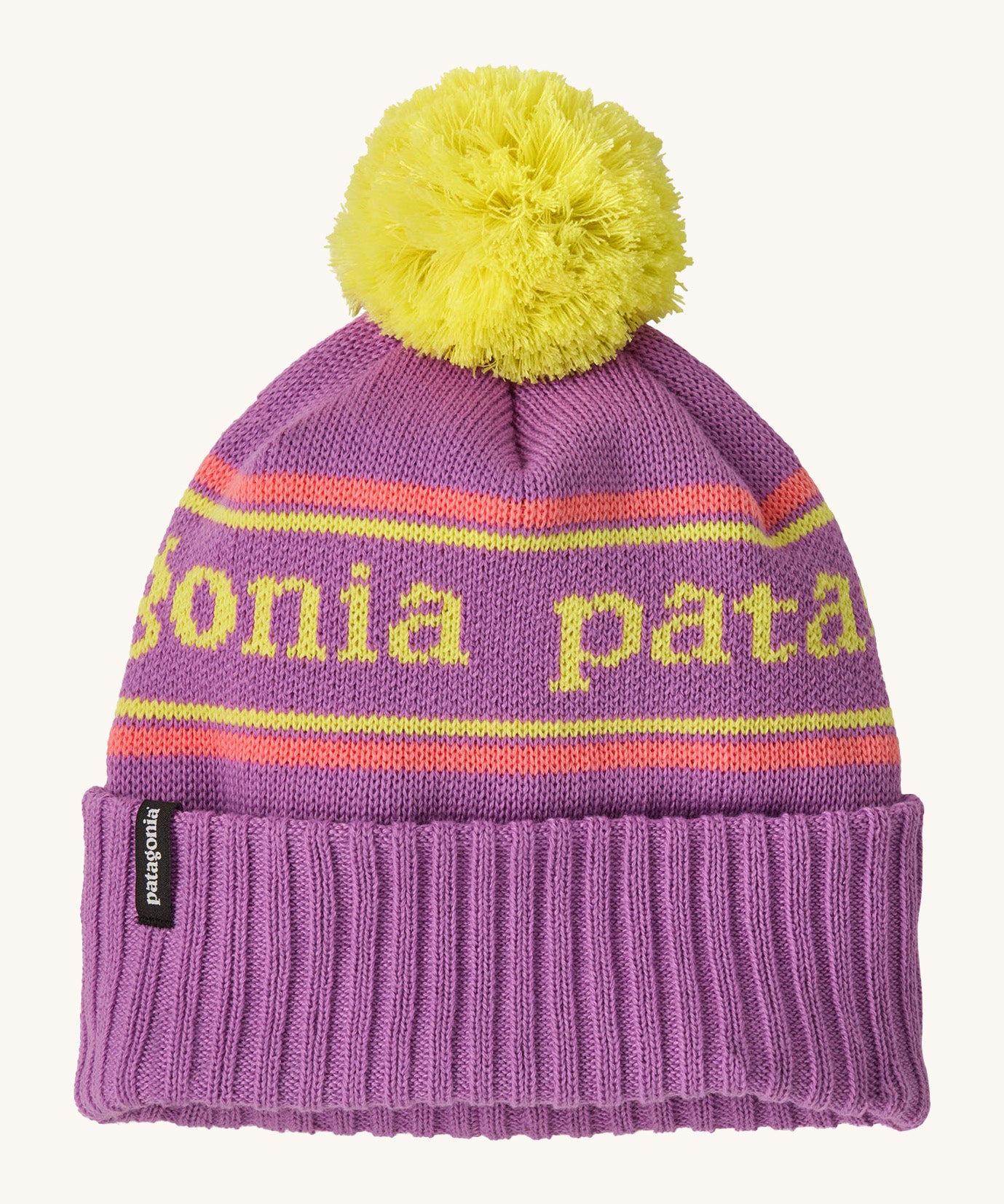 Patagonia kids powder town beanie in park stripe/brisk purple. A thick beanie with the brand name in yellow through the middle on bright purple organic fabric. Features a bright yellow pom pom on top.
