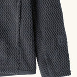 Close up of the side pockets and thumb holes on Patagonia high performance kids R1 air hoody in navy blue. 