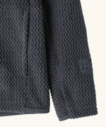 Close up of the side pockets and thumb holes on Patagonia high performance kids R1 air hoody in navy blue. 