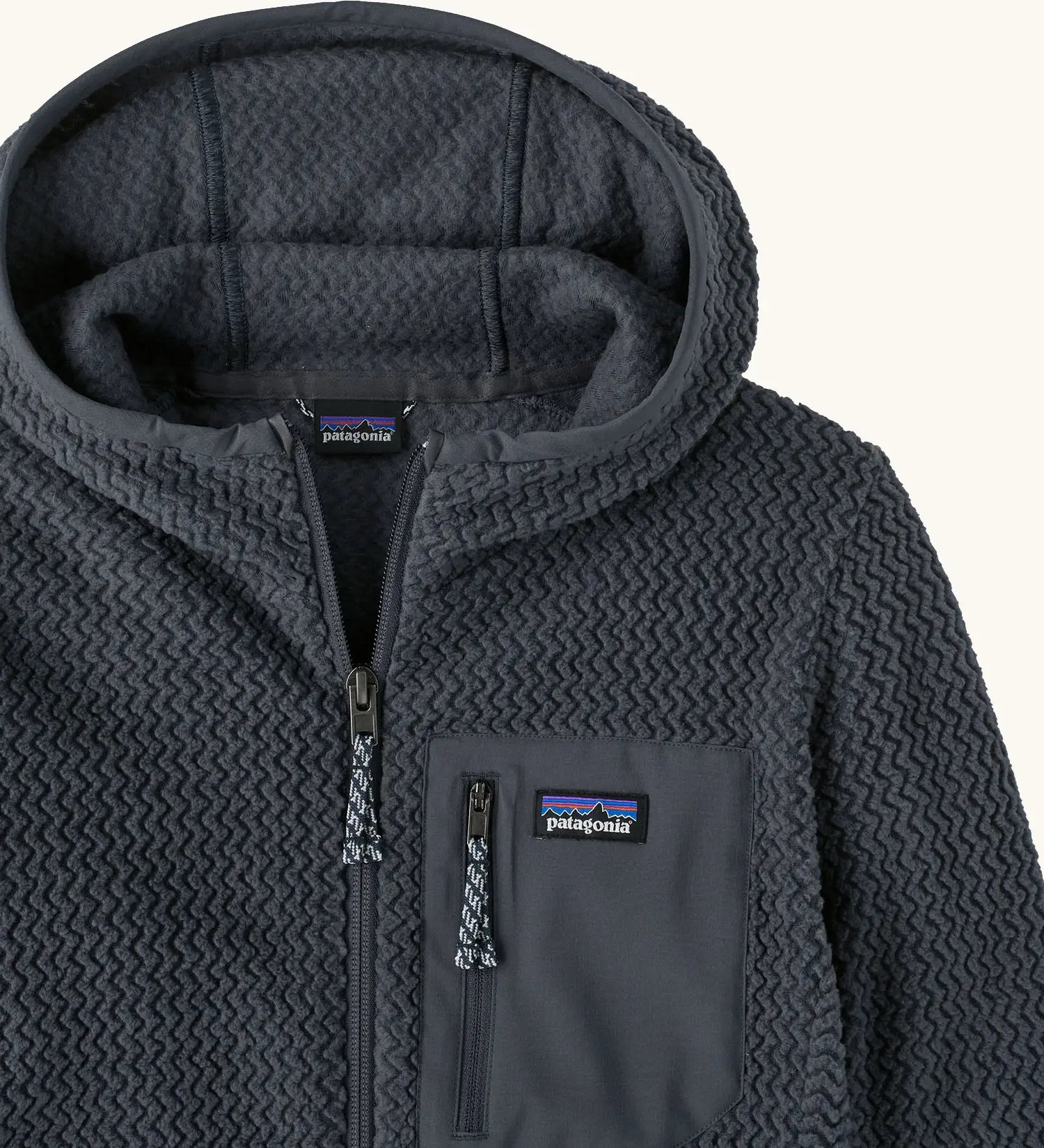 Patagonia high performance kids R1 air hoody in navy blue. Showing the elasticated trim around the hood and zip details