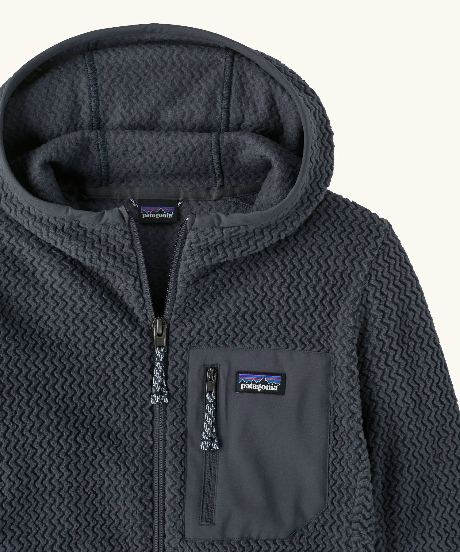 Patagonia high performance kids R1 air hoody in navy blue. Showing the elasticated trim around the hood and zip details