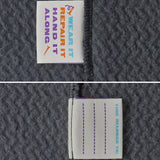 Close up of name tags on Patagonia high performance kids R1 air hoody in navy blue. 