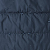 Close up of water droplets pooling on material of the patagonia kids reversible ready freddy hoody water resistant jacket in new navy.