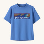 Patagonia kids short sleeve cap tshirt in a light blue colour with logo on a cream background.