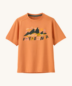 Patagonia kids short sleeve cap tshirt in a peach colour with logo on a cream background.
