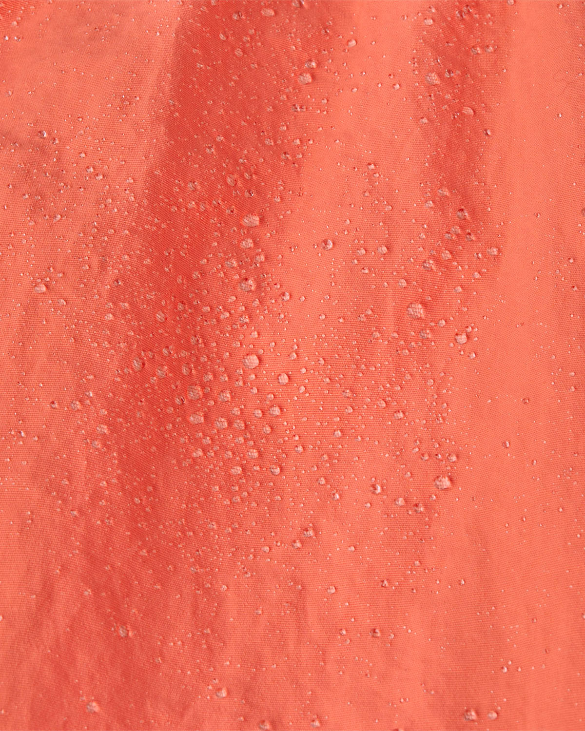 A close up of water droplets on the  surface of the material of a pair of Patagonia Kids Costa Rica Baggies Shorts.